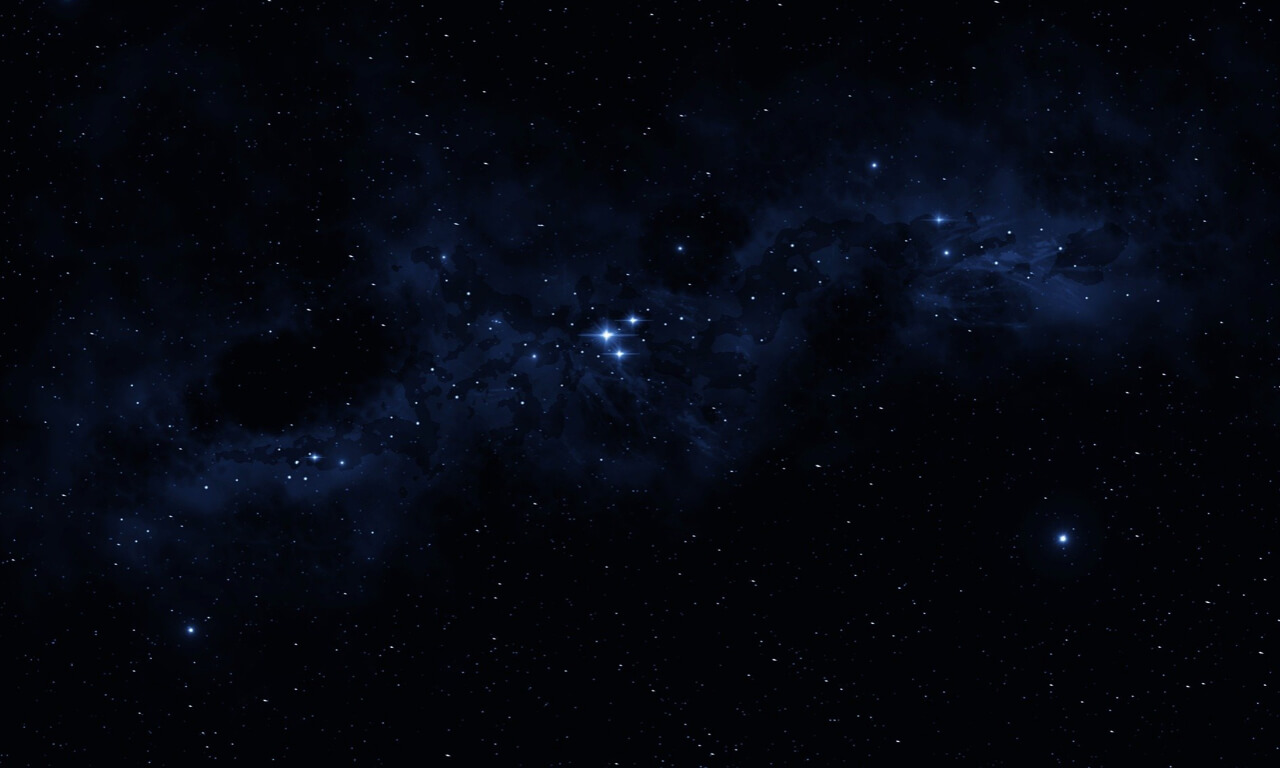 Dark, starry expanse of the night sky with a light nebula running through the center